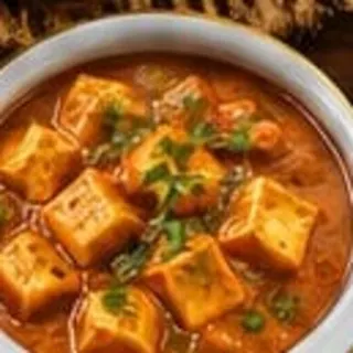 A bowl of paneer in a homestyle gravy